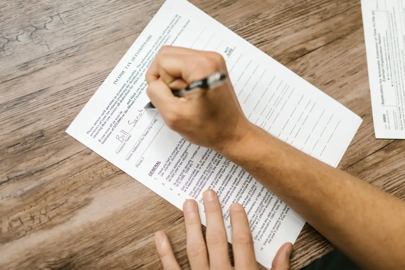 Tờ khai thuế và máy tính trên bàn — MAGI từ tờ khai thuế quyết định mức IRMAA Medicare của quý vị