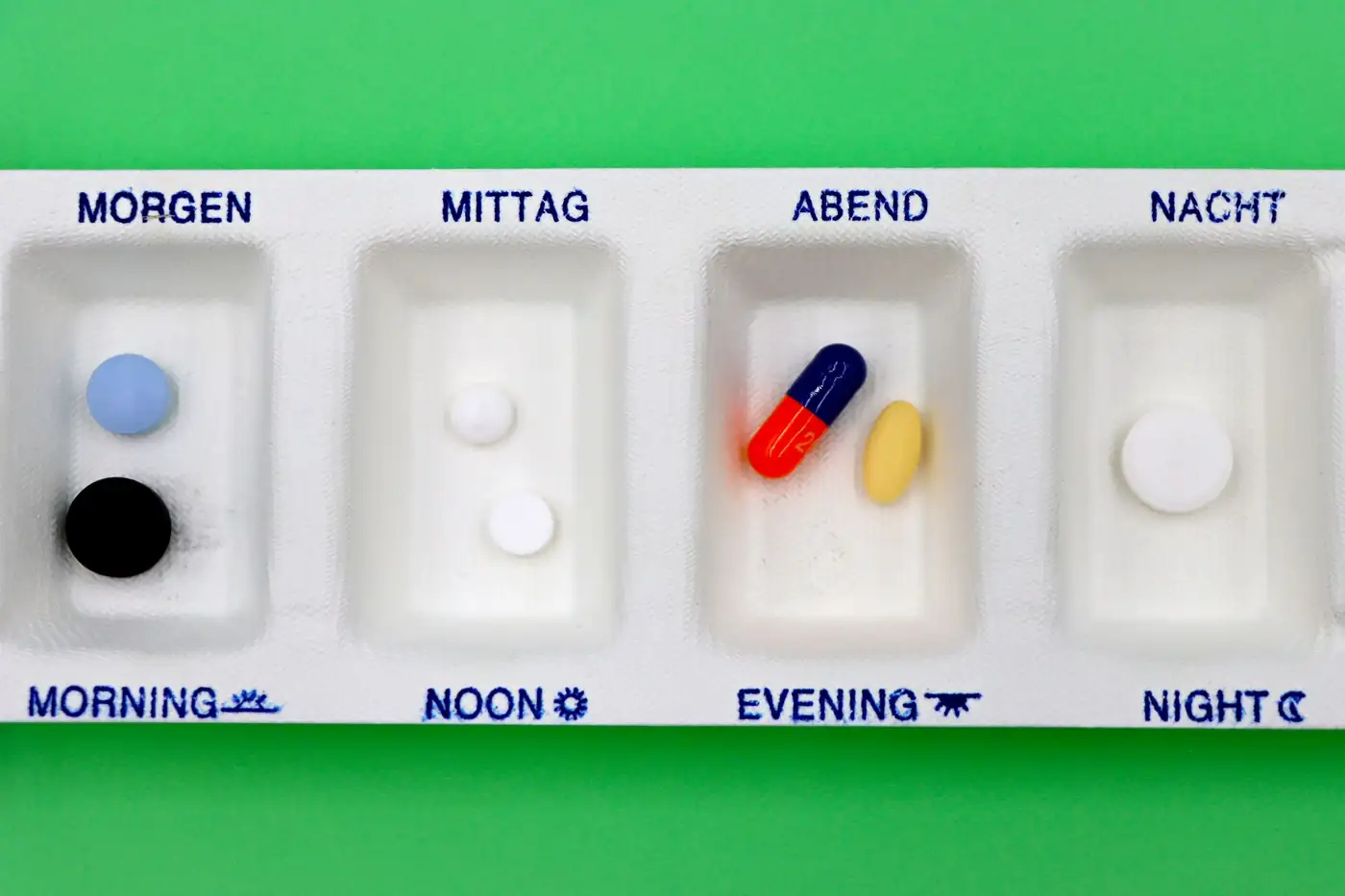 Một cụ cao niên sắp thuốc vào hộp chia thuốc theo tuần — chương trình M3P cho phép trải chi phí thuốc túi tiền thành các khoản trả góp hàng tháng 0% lãi