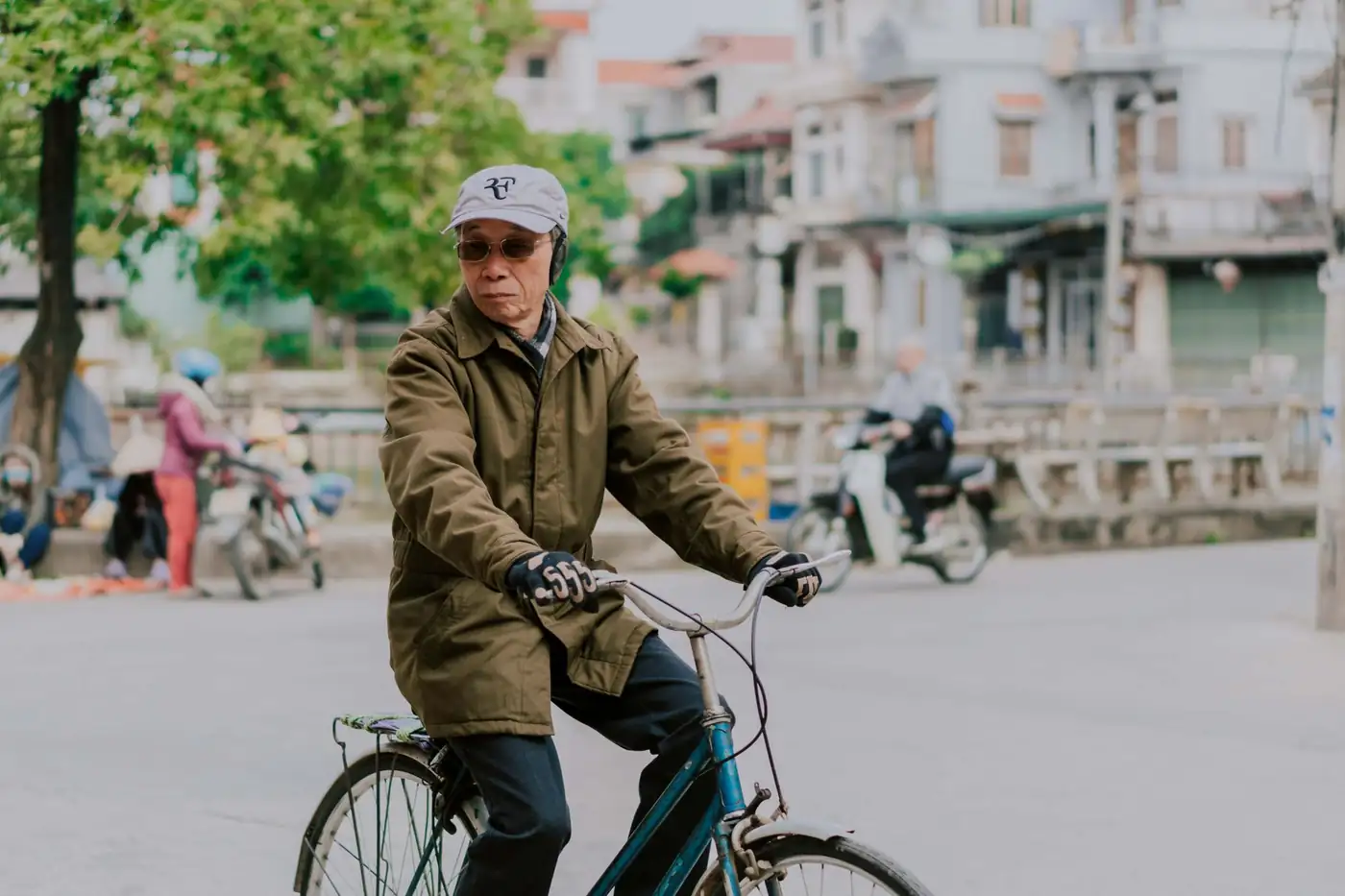 Một chuyên viên bảo hiểm giải thích giấy tờ cho một cặp cao niên đang lo lắng — Bảo Hiểm Kim Anh giúp quý vị hiểu WISeR bằng tiếng Việt